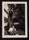 Esther Morgan and an unidentified man in front of palm tree